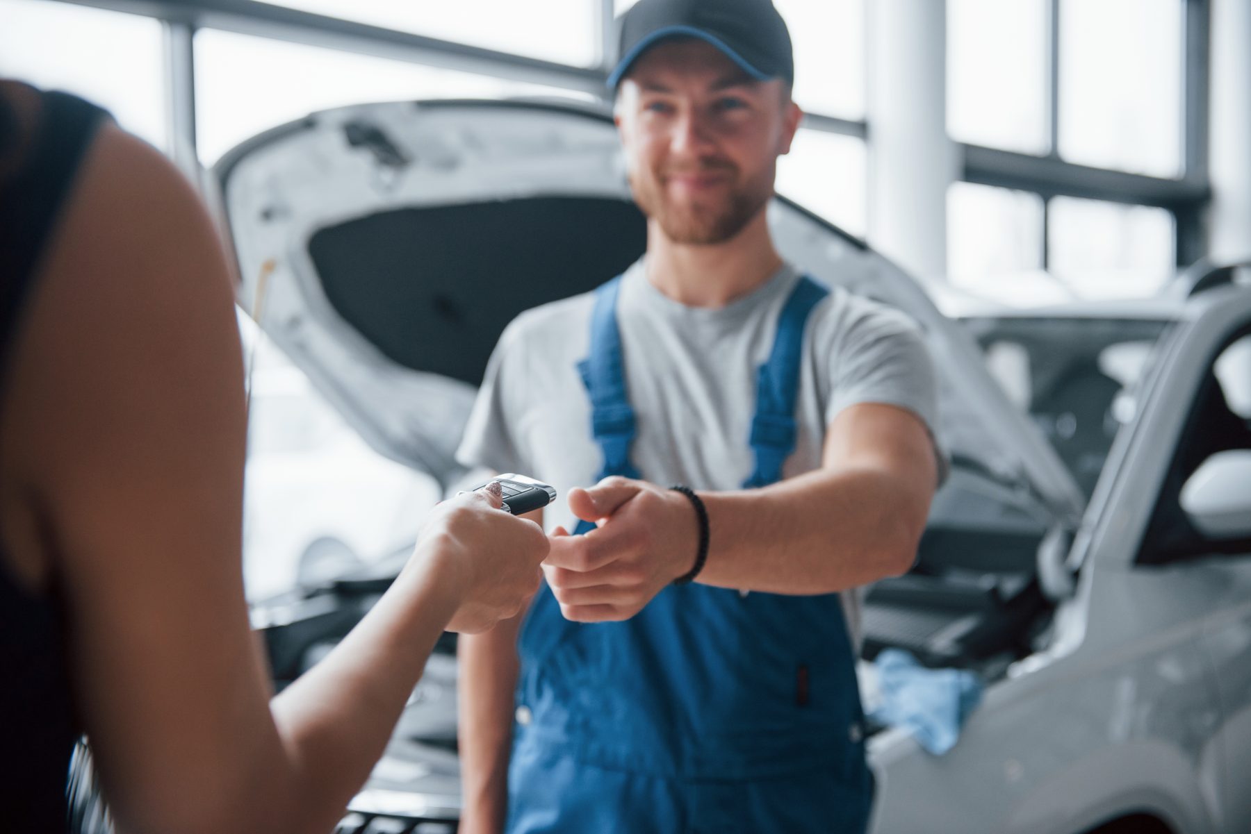 Un meccanico consegna le chiavi dell'auto a una cliente in officina